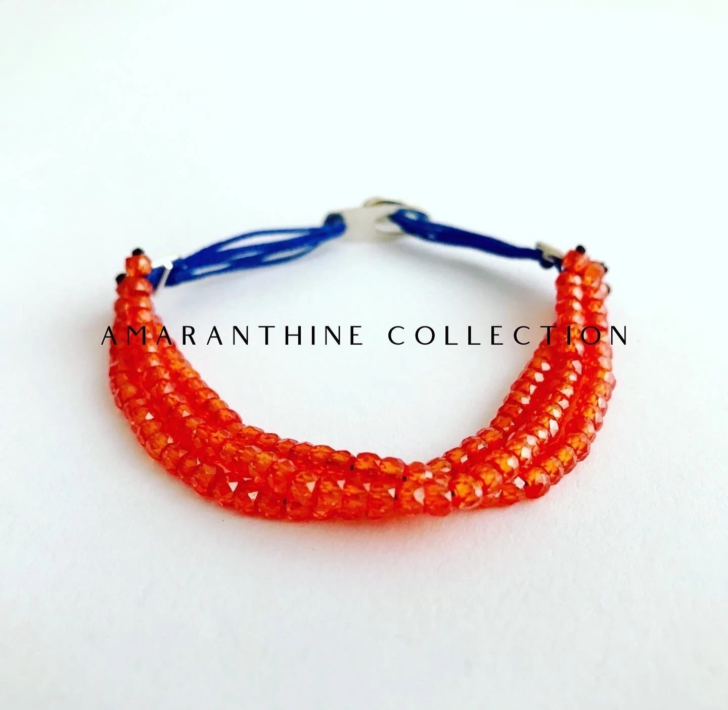 Handmade bracelet set with three lines of high quality faceted carnelian beads strung on a navy colored saten string. Amaranthine signature handmade silver clasp.