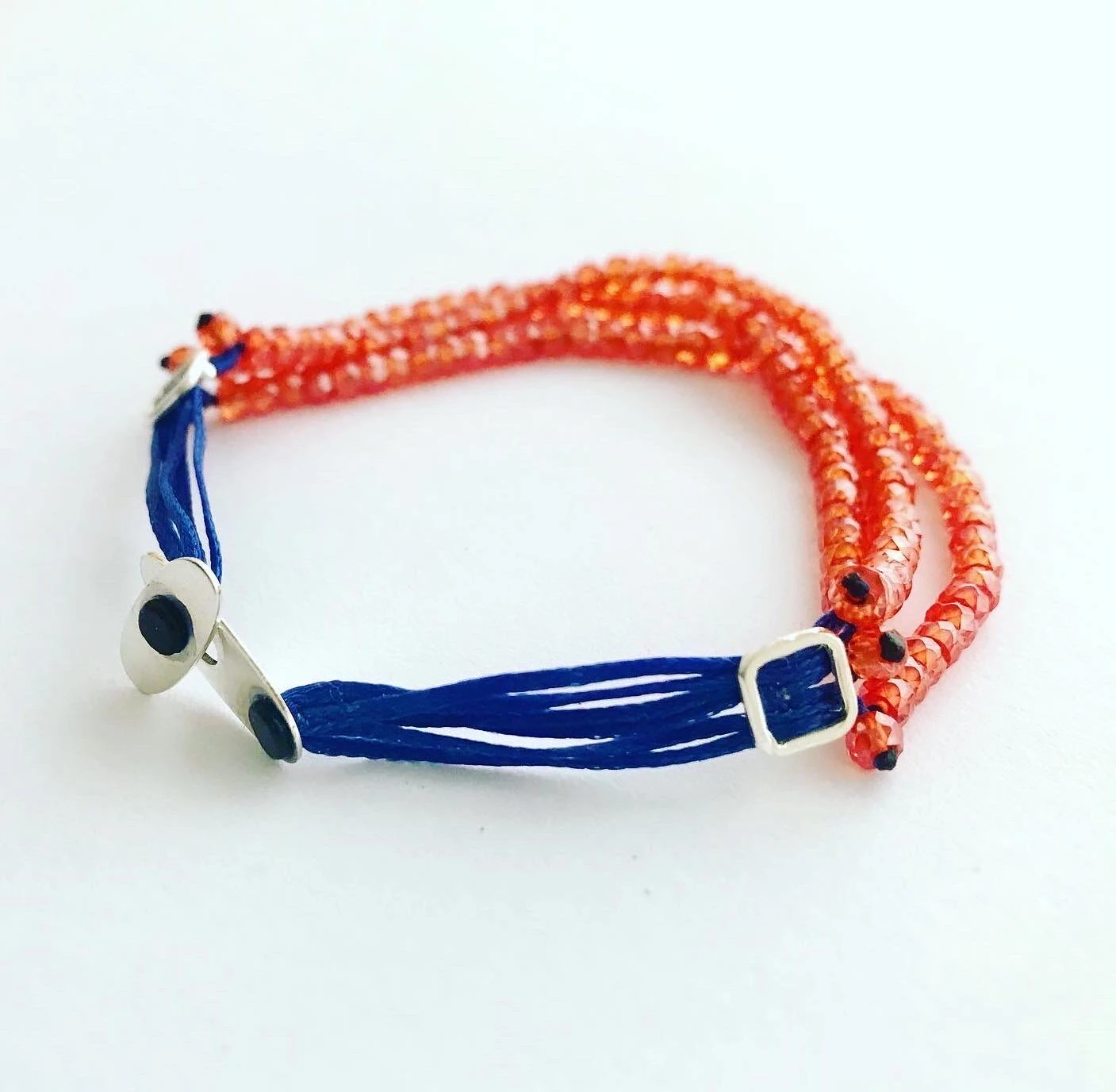 Handmade bracelet set with three lines of high quality faceted carnelian beads strung on a navy colored saten string. Amaranthine signature handmade silver clasp. — slika 2