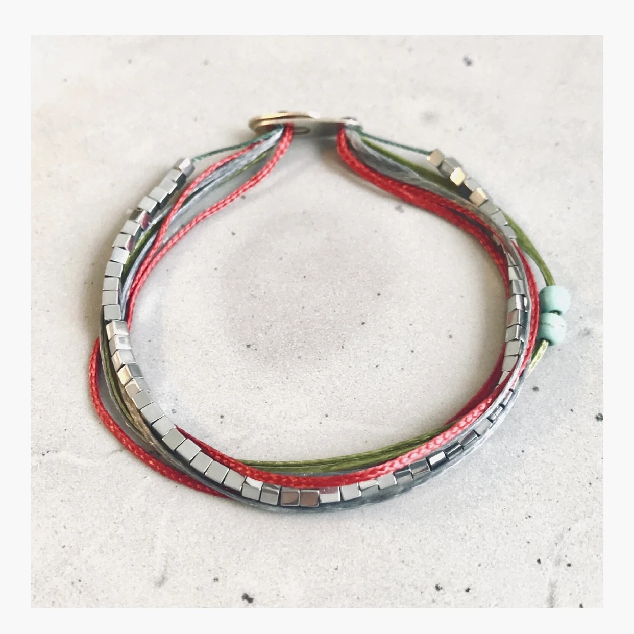 Handmade bracelet - seven colorful strings and hematite cubes. A couple of turquoise beads for good measure. Handmade Amaranthine signature silver clasp.